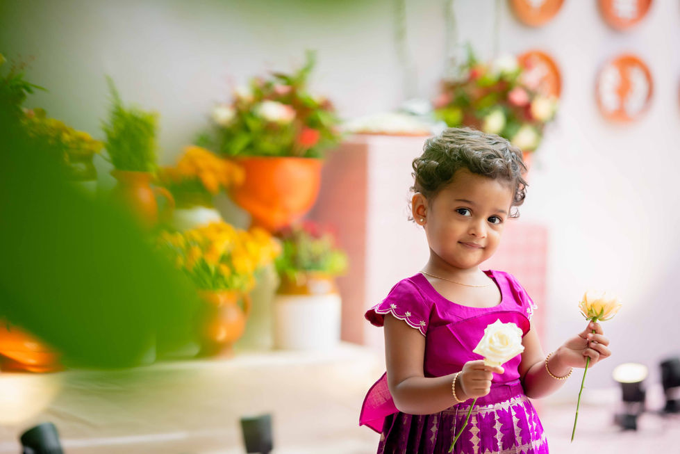 Child holding ice cream, colorful background, flowers visible.