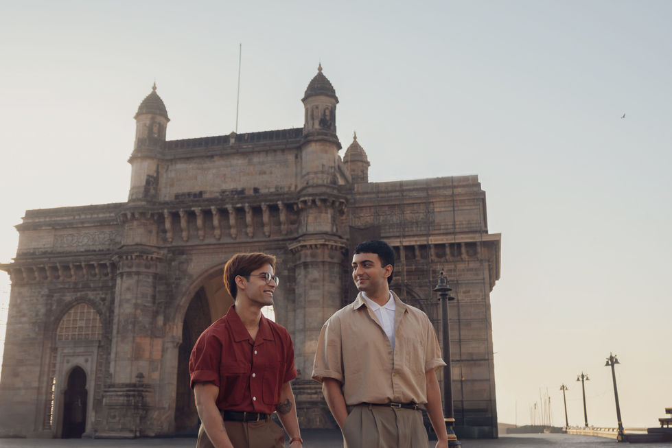 Two people smiling near Gateway of India.