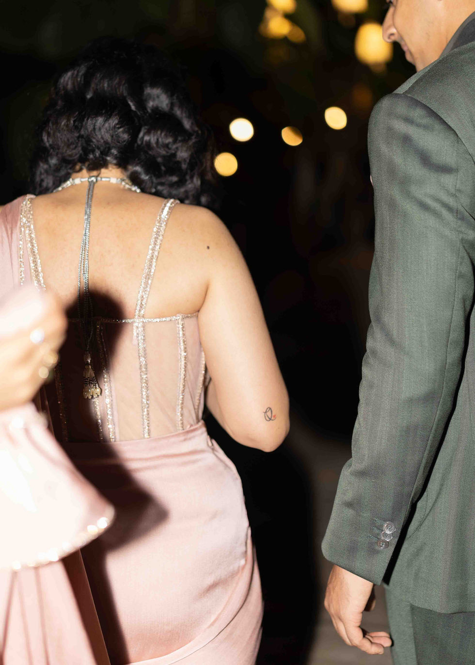 Two people walking, one in a pink dress.
