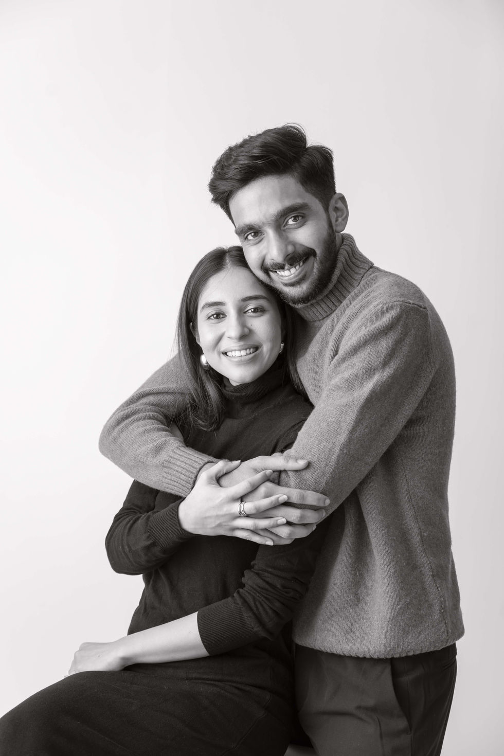 A couple embracing and smiling in black and white.