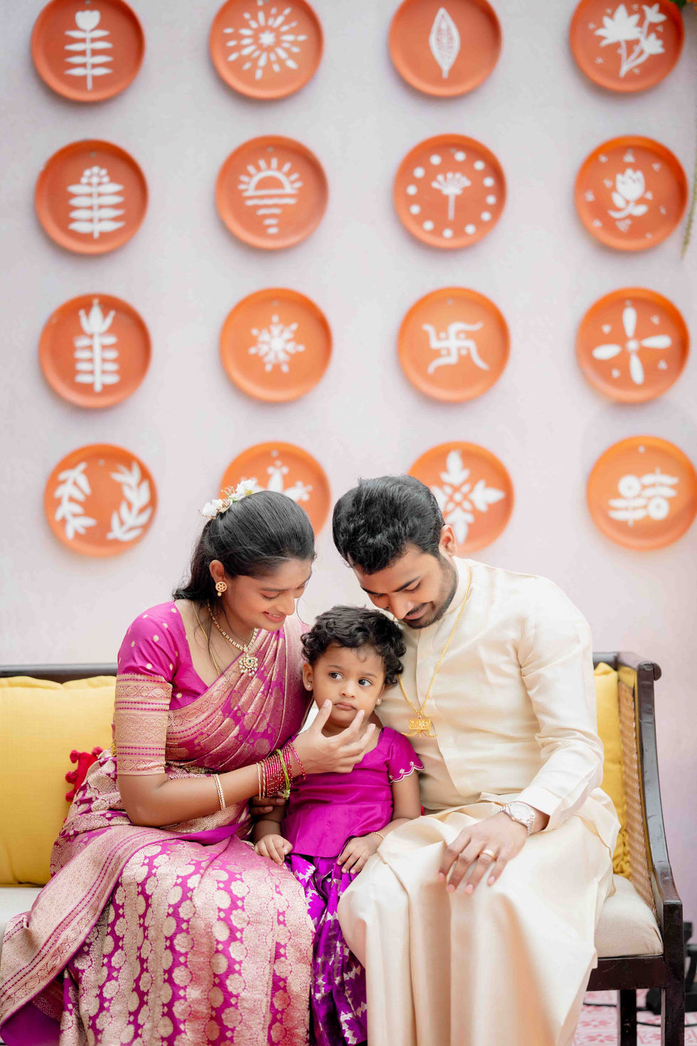 Family sitting together, decorative plates on wall.