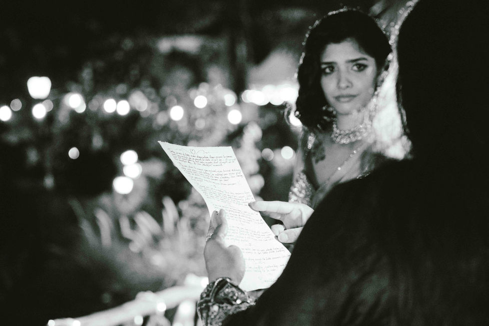 Black and white photo of a woman reading paper.