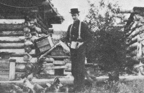 Walter Williamson beside a log cabin near Wildwood, Alberta, circa 1910s.