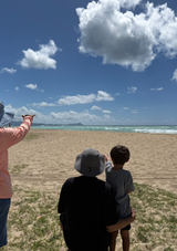 3 participants looking east toward the Koʻolau mountain range from Puʻuloa beach park.