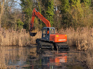 Orange digger clearing brown reed beds