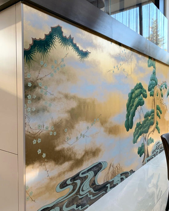 Wall covered in abstract designer wallpaper with gold and green elements