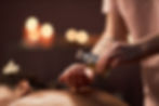 Mains du thérapeute du spa qui applique de l'huile de massage sur le dos du client.jpg