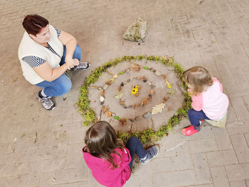 Enfants participant à une activité nature autour d'une création réalisée avec des éléments naturels.