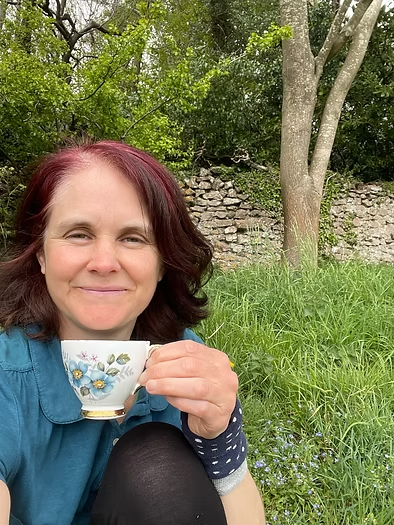 a woman drinking tea outside in nature