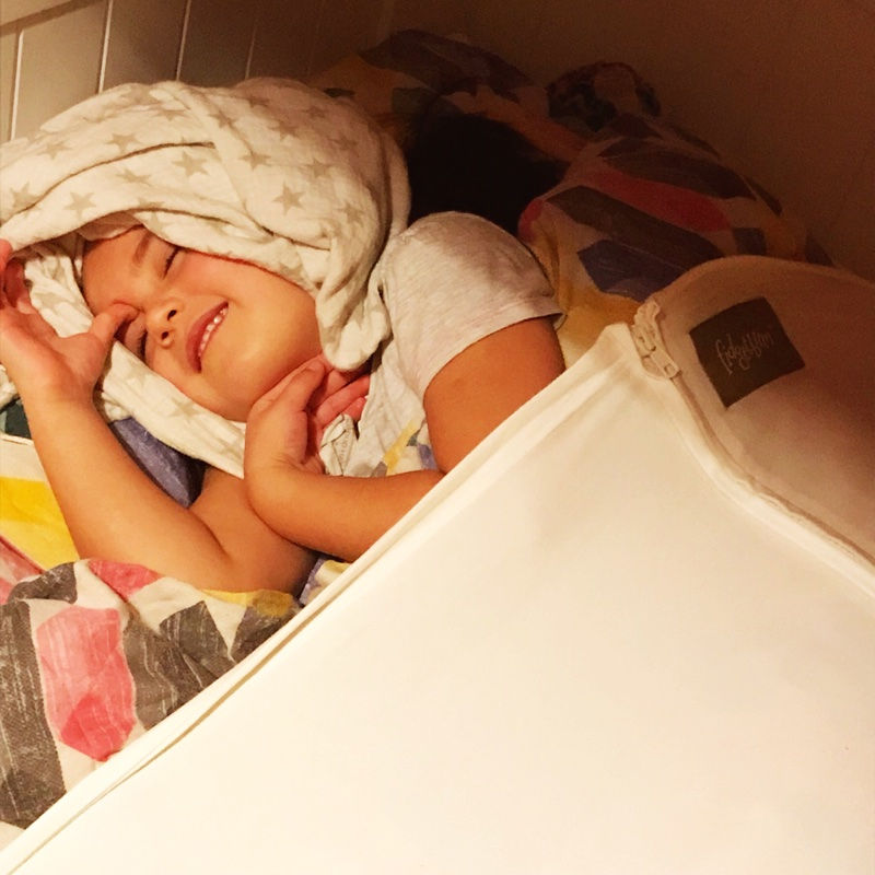young girl tucked up in bed
