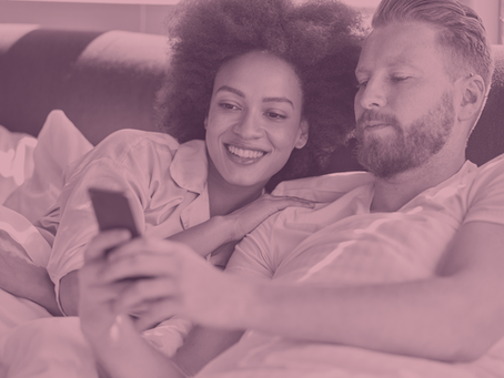 A couple in bed with an intimacy app