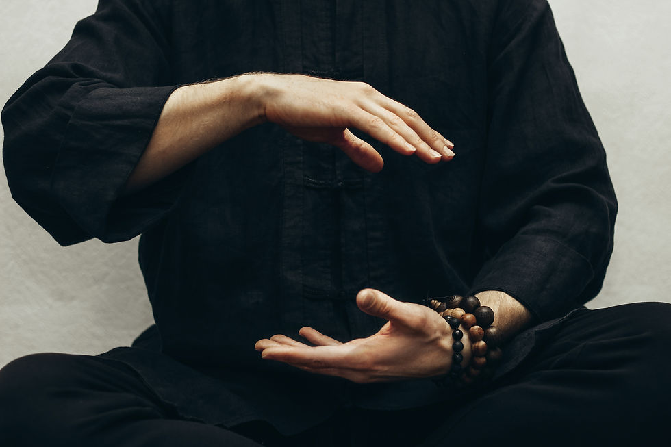 A person in traditional attire practices kung fu with focused hand movements, wearing a wooden bead bracelet.