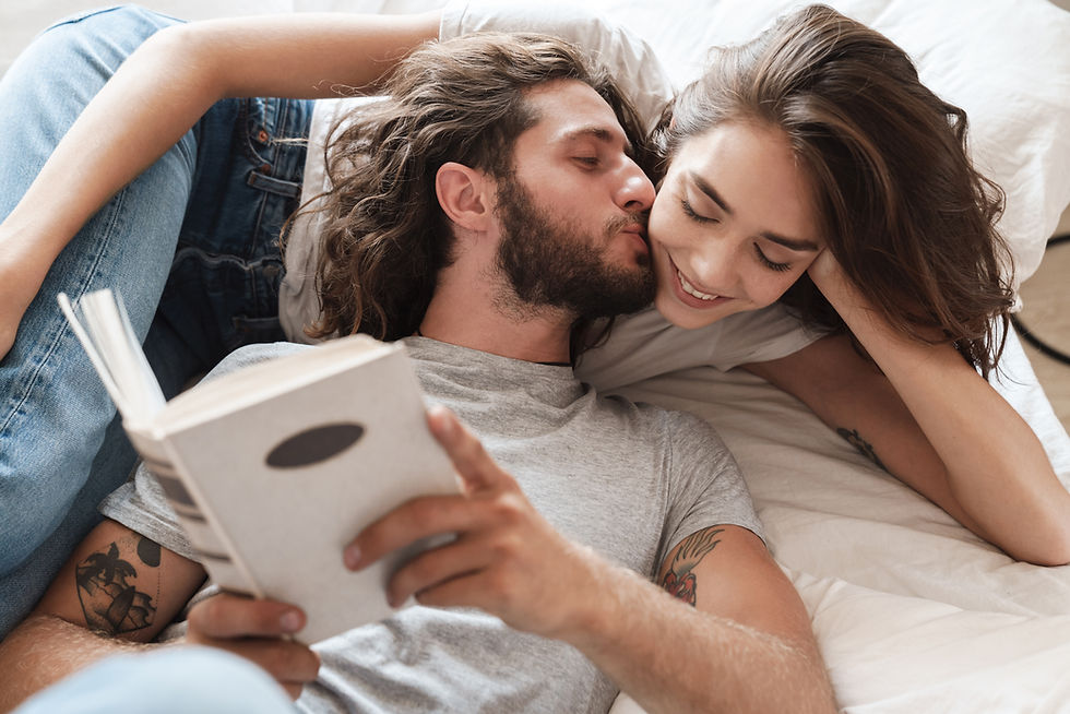 A loving couple shares a tender moment, enjoying each other's company while relaxing with a book.