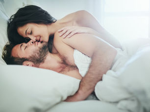 A couple in bed under white sheets