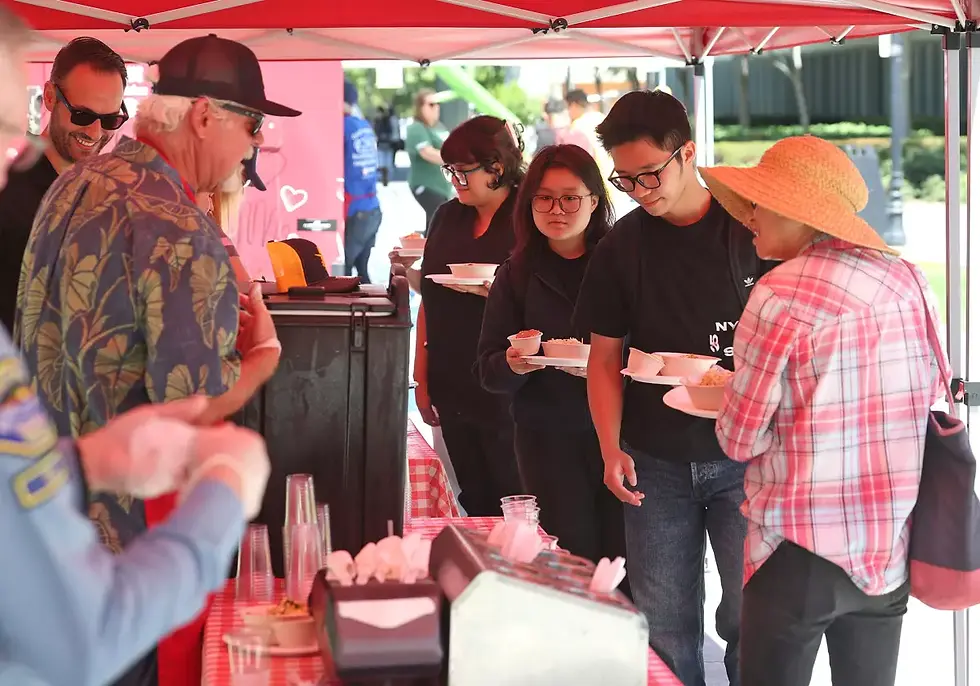 Huntington Beach Mayor Pro Tem Butch Twining serves students bowls from Bracken’s Kitchen food truck during Welcome Week at Golden West College on Tuesday.
