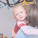 Woman holding a child during therapy.