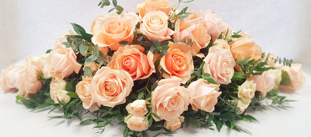 Casket Spray with peach avalanche roses, spray roses, long ruscus, eucalyptus