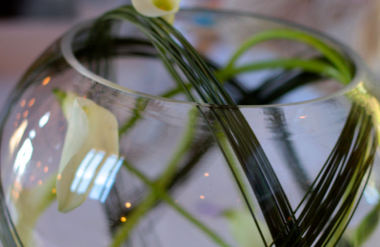 Reception Table Arrangement in Large bowl with glass pebbles, calla lilies, bear grass and floating candles, Edenbridge florist