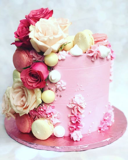 A pink birthday cake with pink and white macaroons by A Piece of Cake and Desserts of Tampa Florida