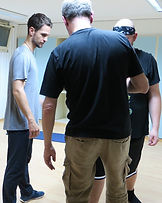 Teilnehmende eines Tai-Chi-Kurses üben gemeinsam achtsame Bewegungen in einem Kursraum.