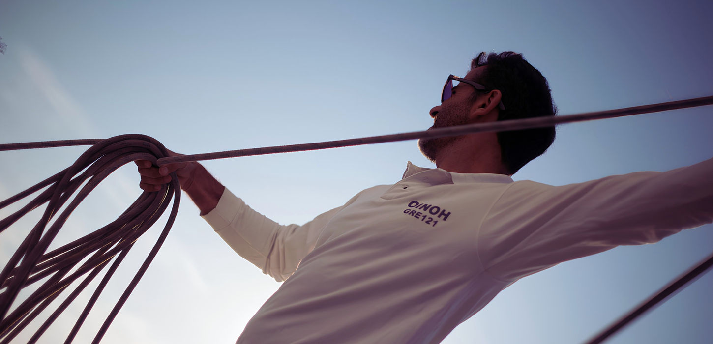 Crew trimming sails during active sailing experience on yacht in Crete