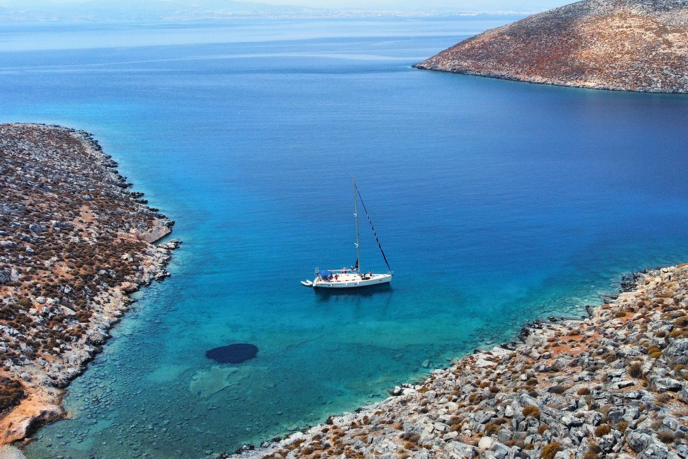 Spanaki Bavaria 41 sailing yacht aerial view in turquoise bay in Crete