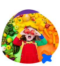 young child in colorful clothing surrounded by colorful food