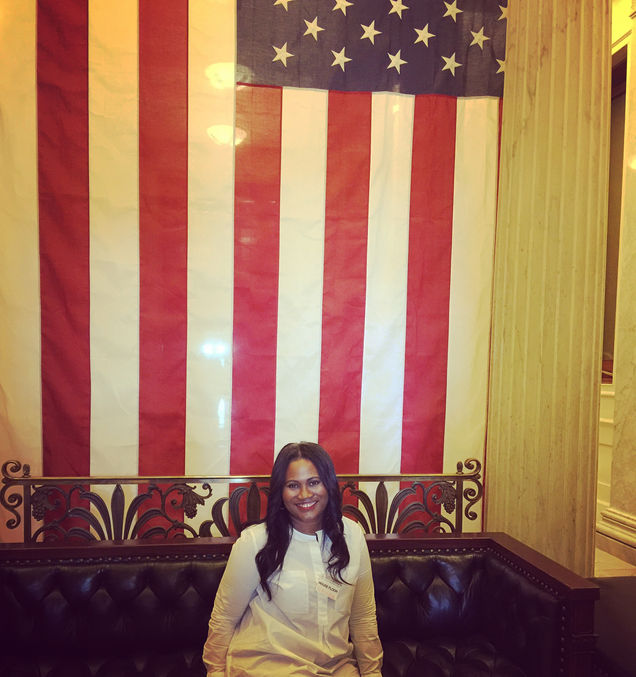 Tracey Baker-Simmons at the White House sitting in front of the American flag