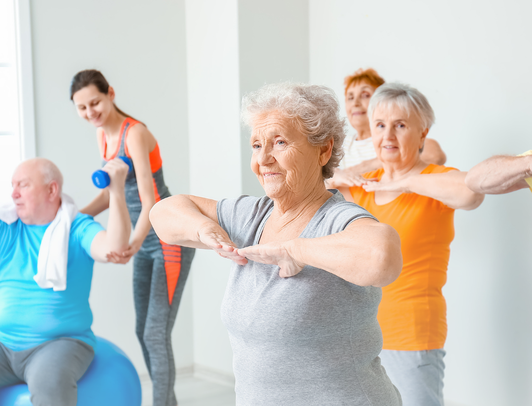 group exercise class with trainer correcting an exercise technique in the background