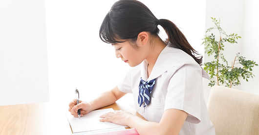 机に向かう女子生徒
