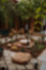 Elegant Moroccan courtyard with lush greenery, a serene water fountain adorned with rose petals, and cozy seating areas offering a tranquil retreat atmosphere.