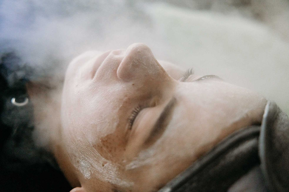 A person lying with closed eyes, face covered in steam, conveying relaxation. Soft lighting, neutral tones, and a tranquil atmosphere.
