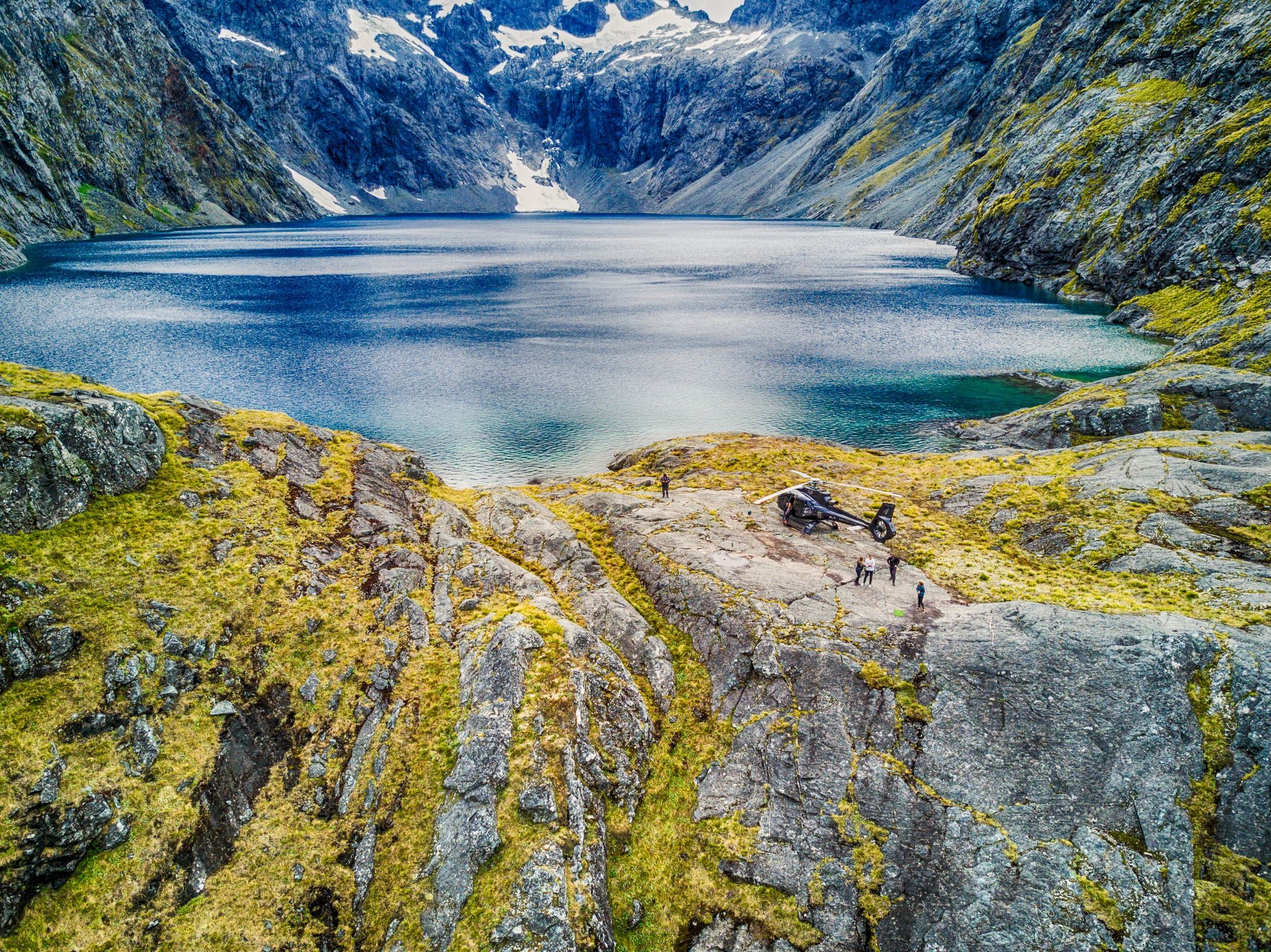 Helicopter landed on rock above Lake Marian in Fiordland, New Zealand