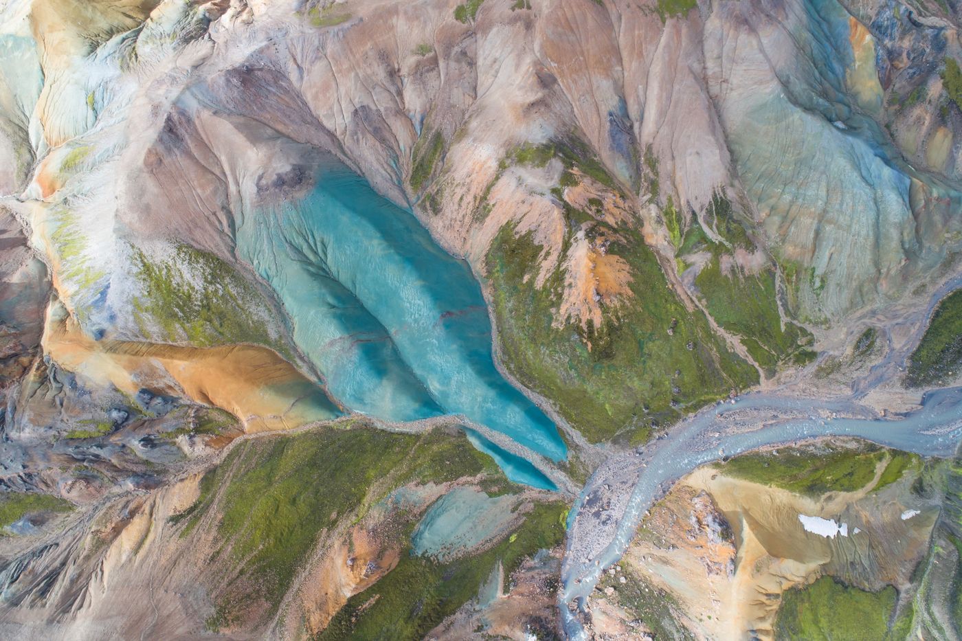 Turquoise glacial water between coloured rhyolite hills, Iceland, from directly above