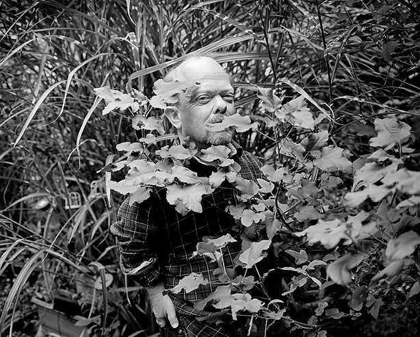 Ritratto di una persona con nanismo che emerge da un groviglio di vegetazione | love, sex and relationships