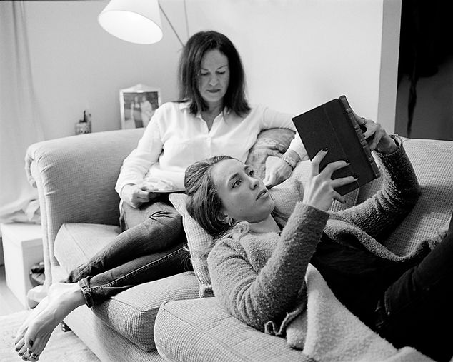 Portrait of a mother and her daughter reading on a sofa | love, sex and relationships
