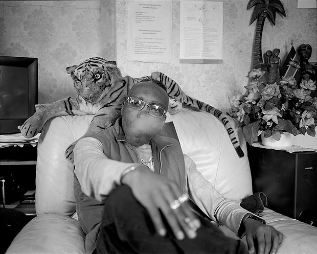 Portrait of a man who went through a family separation, smoking a cigarette in his home armchair | love, sex and relationships