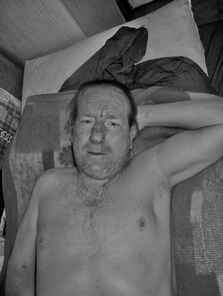 Intimate portrait of a man lying in bed, capturing a quiet and personal moment | Photography masterclass on intimacy in portraiture.