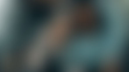 A portrait of a diverse group of women smiling while sitting together on a colourful staircase.