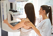 technicienne qui indique à la patiente comment se positionner sur la machine de mammographie