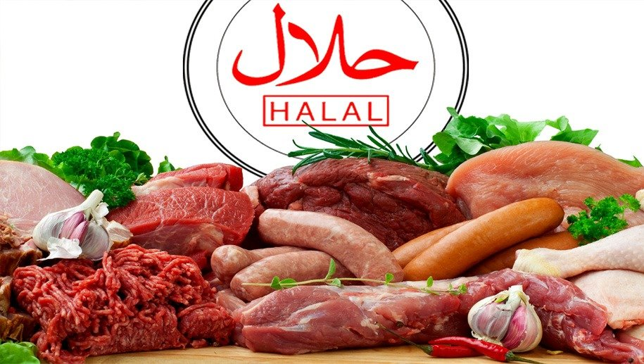 Assorted halal meats on a wooden surface with herbs and garlic. "Halal" text in red and white above. Fresh and colorful display.