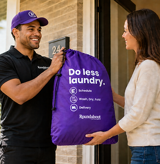 A Roundabout delivery driver in his purple hat and polo, handing a bag to a customer who is happy to have their laundry back.