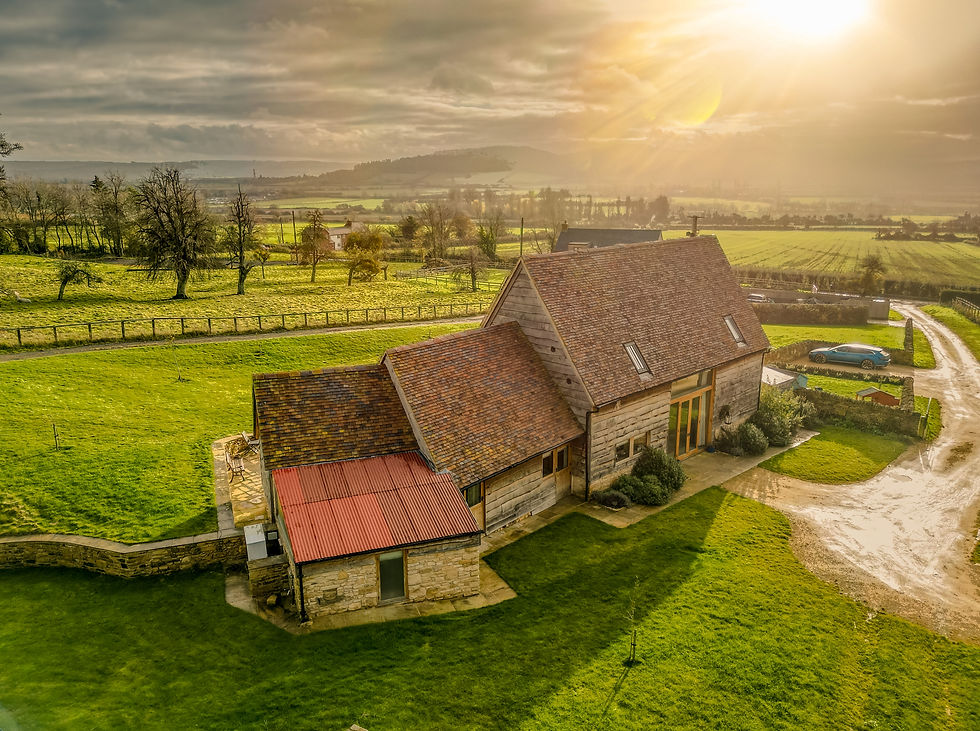 Beautifully converted barn in a rural setting with the sun setting behind