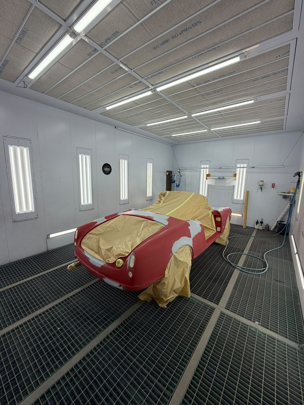 Arrière d'Alfa Romeo Giulietta Spider protégée par du papier de masquage en cabine, Saint-Rémy-de-Provence