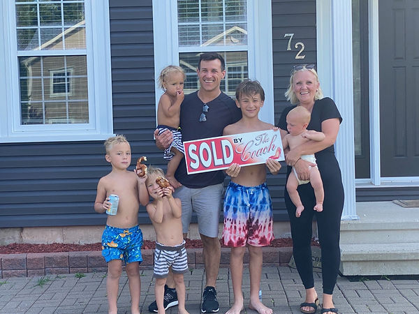 Family posing outside of their new home