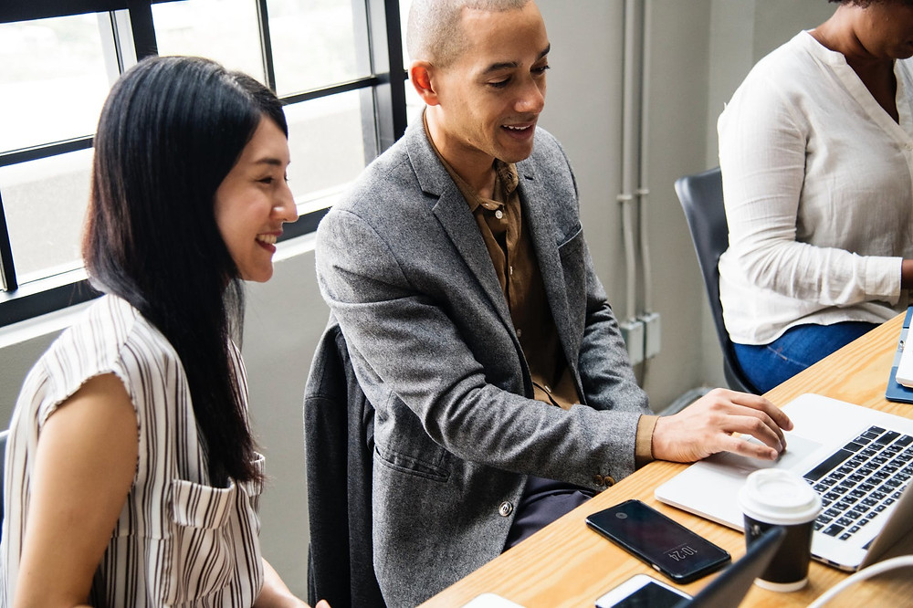 man and woman looking at computer during meeting
