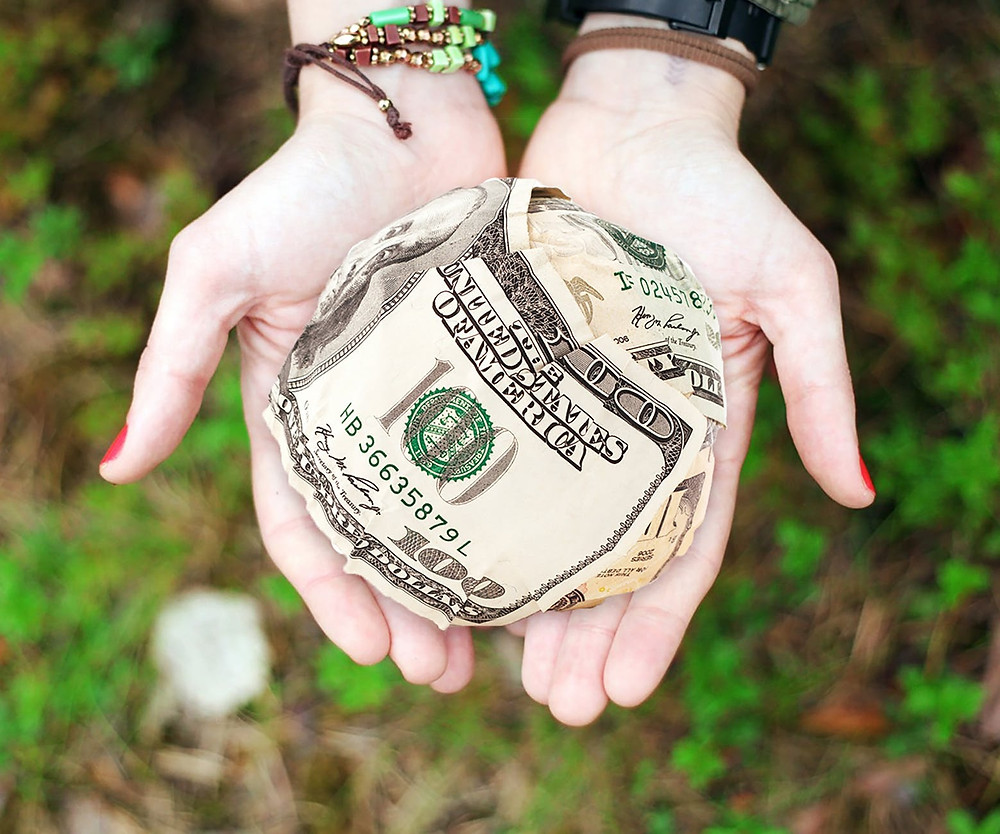 Hands holding a ball of money