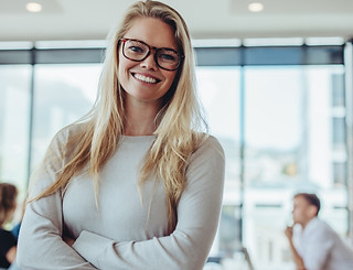 Portrait of confident businesswoman with colleagues in boardroom. Positive woman with cowo