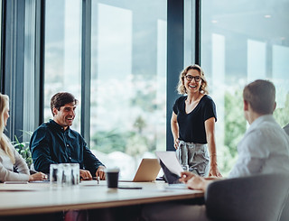 Office colleagues having casual discussion during meeting in conference room. Group of men