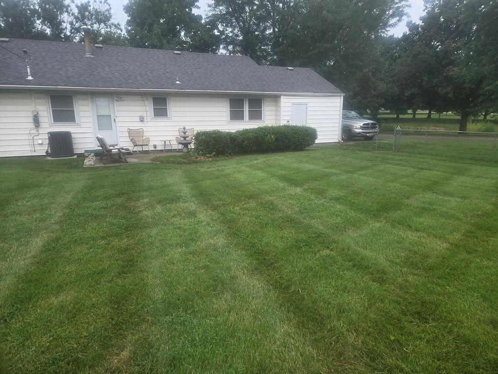 Freshly mowed backyard lawn with clean mowing stripes and neatly maintained landscaping by Lawn Care Topeka in Topeka, Kansas.